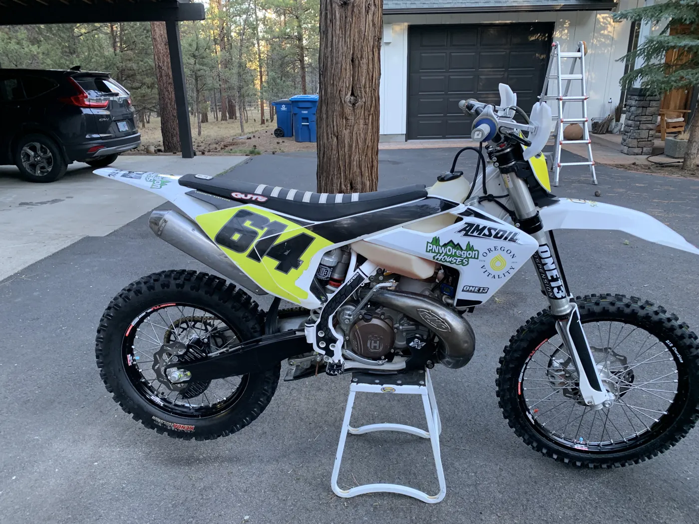 White and yellow Husqvarna race bike, number 614, on a stand